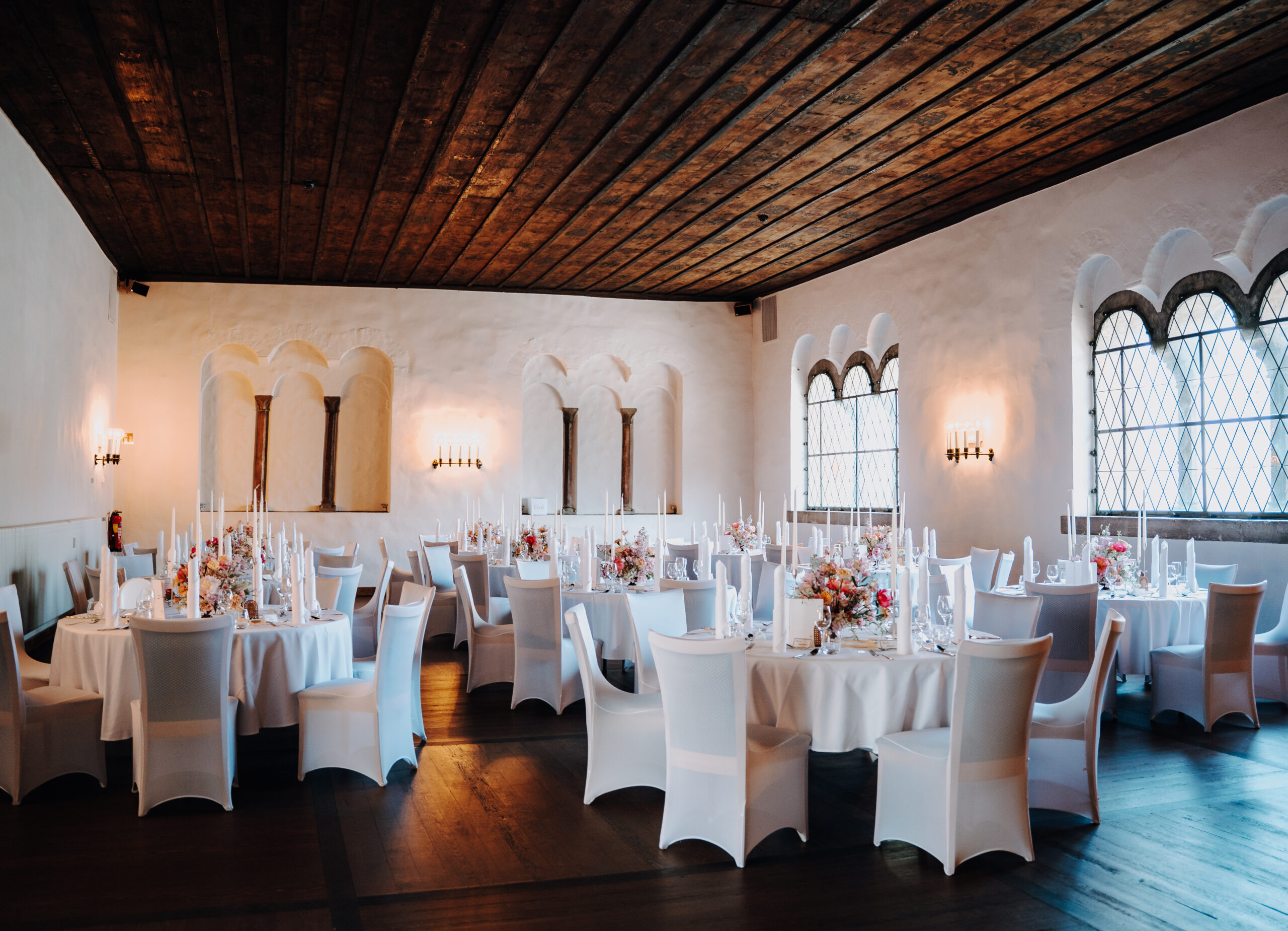 Der Herzogssaal ist festlich hergerichtet. Mehrere Tische in weiß stehen in Bankett Form angeordnet bereit, um die Hochzeitsfeier perfekt zu machen