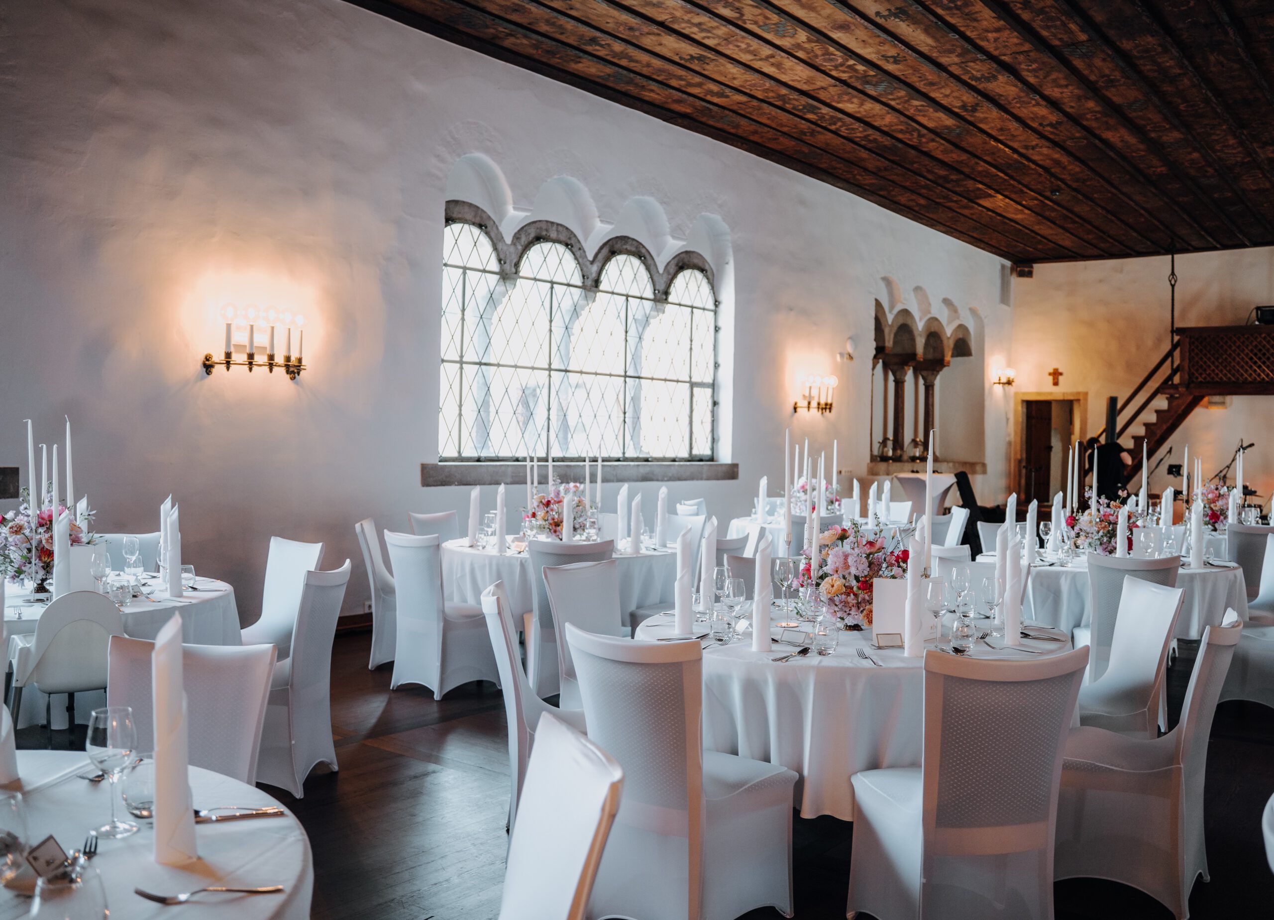 Der Herzogssaal ist festlich hergerichtet. Mehrere Tische in weiß stehen in Bankett Form angeordnet bereit, um die Hochzeitsfeier perfekt zu machen