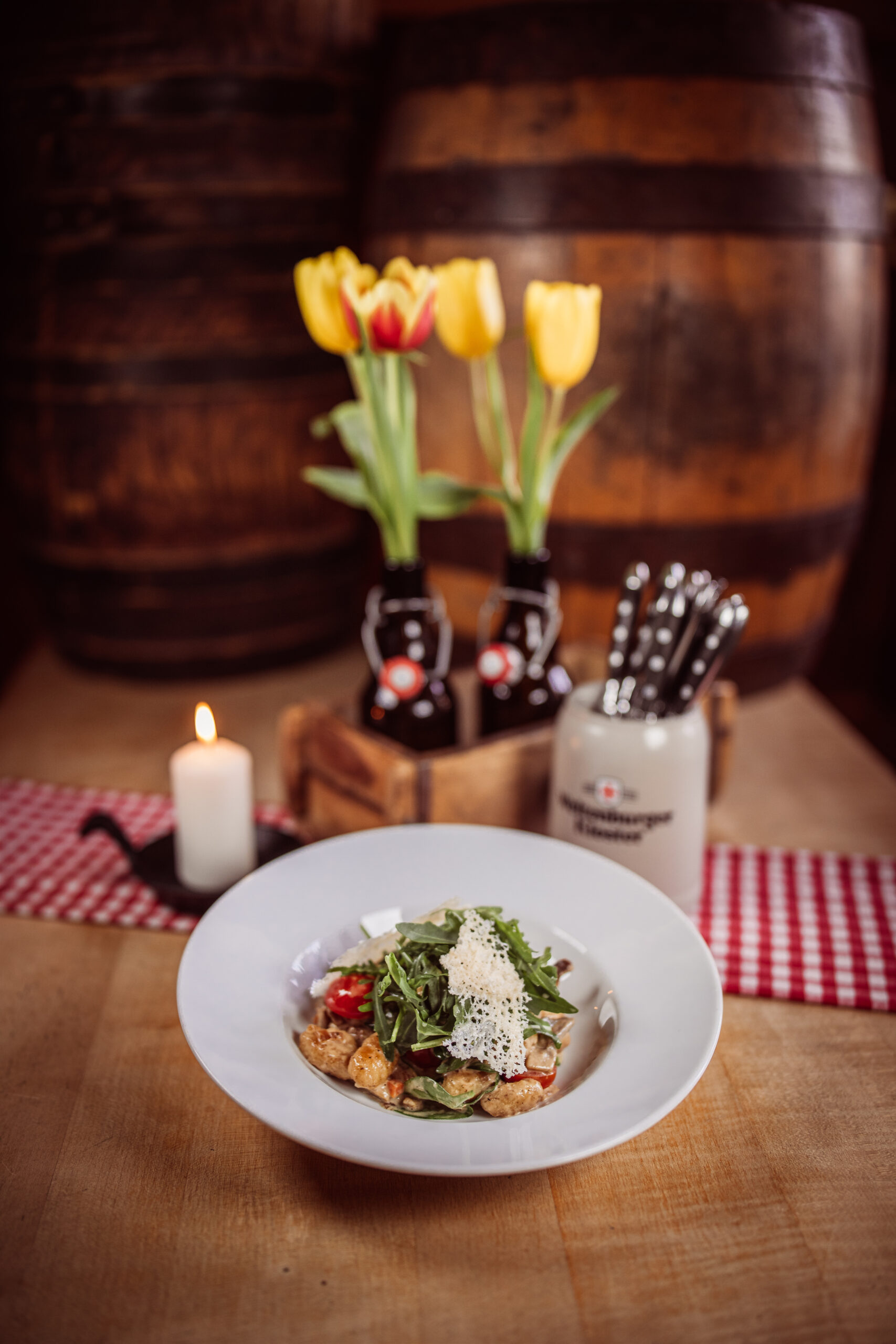 Appetitliches Foto einer Nockerlpfanne. Die Nockerl, kleine, unregelmäßige Teigstücke, sind in einer cremigen Soße geschwenkt.