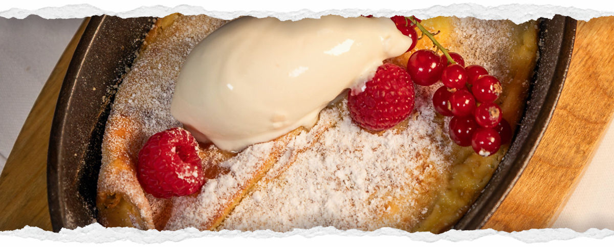 Topfenpalatschinken mit Himbeeren und Johannisbeeren garniert
